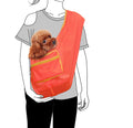 Orange pet sling with a small brown dog inside, worn by a person.